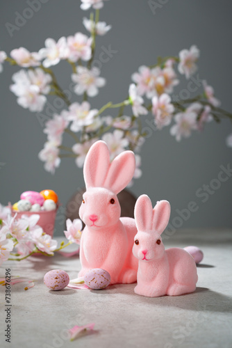 Two pink Easter bunny decor and some chocolate eggs pink flowers