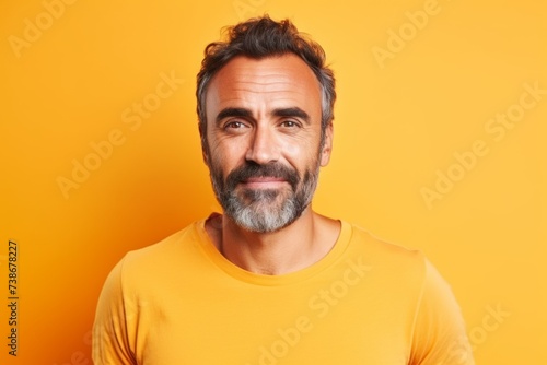 Portrait of handsome mature man with beard and mustache on yellow background