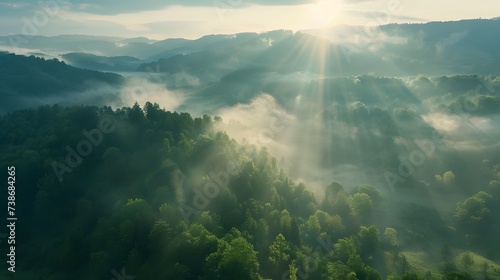 Beautiful aerial View of hilly landscape in morning mist with sun rays, banner format 