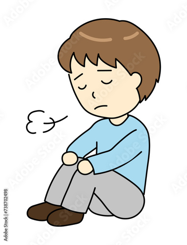 体育座りでため息をつくうつ病の若い男性