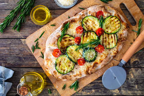 Pinsa Romana with mozzarella cheese and grilled zucchini and rosemary on wooden table photo