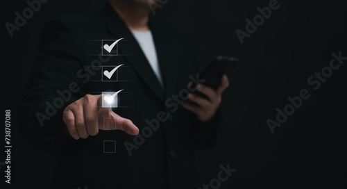 Businessman uses mobile for online assessments and surveys. Showcases digital checklists and performance evaluations for efficient task management photo