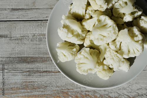 Organic cauliflower on white wooden table top.