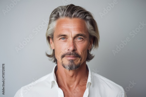 Portrait of handsome mature man. Isolated on grey background.