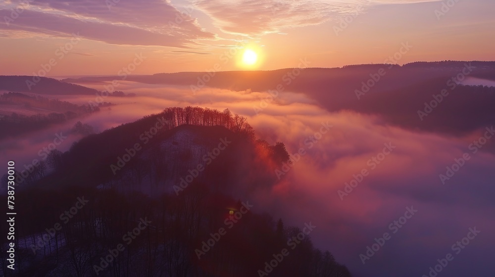 Drone view of sun rising over fog shrouded welzheim forest