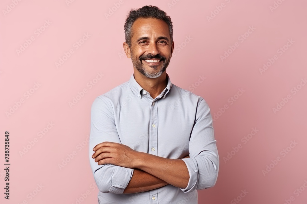 Portrait of a handsome middle-aged man with crossed arms against pink background Portrait of a handsome middle-aged man with crossed arms against pink background