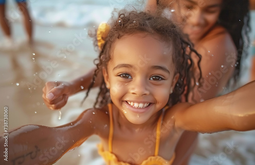 Joyful young girl with curly hair playing on the beach with her mother in the background, family vacation concept.