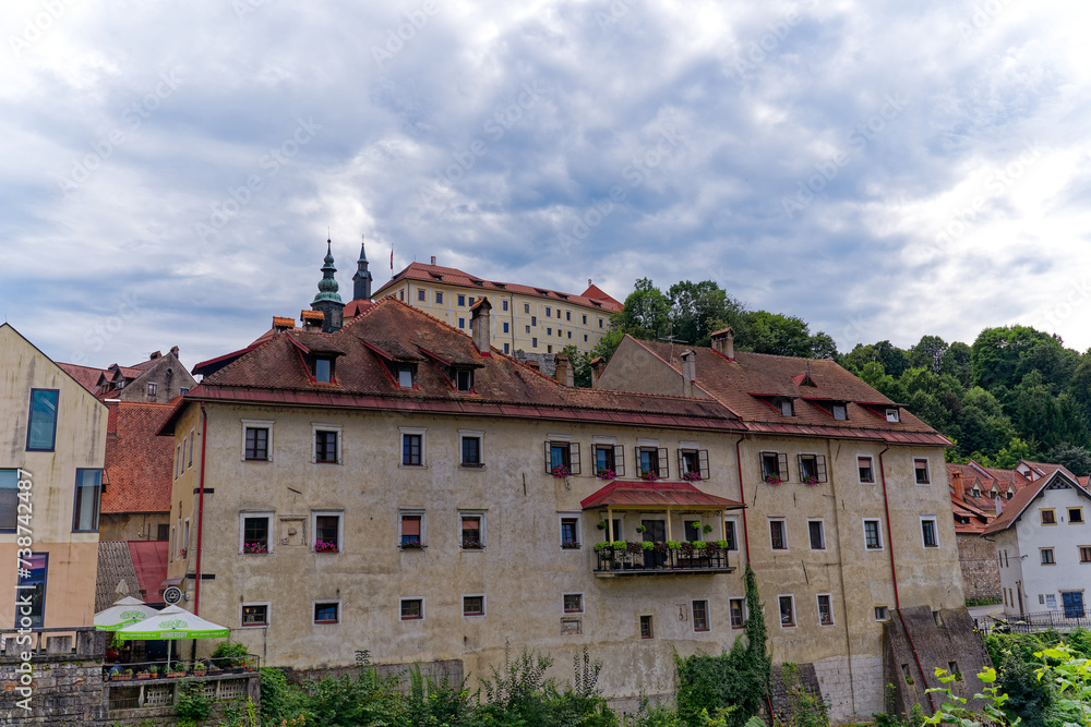 Old town with historic houses and castle on a hill at Slovenian City of Skofja Loka on a cloudy summer day. Photo taken August 9th, 2023, Skofja Loka, Slovenia.