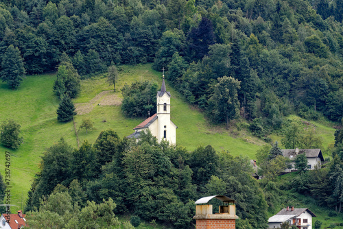 Holy Cross Church at Pustal settlement on a hill at municipality of Slovenian City of Skofja Loka on a cloudy summer day. Photo taken August 9th, 2023, Škofja Loka, Slovenia.
