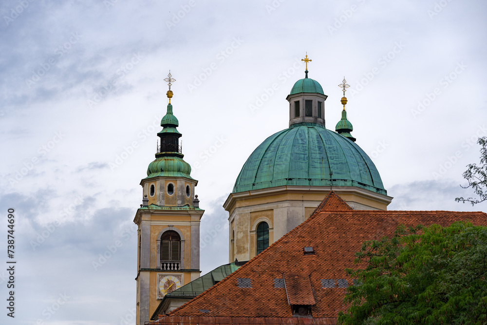 Church tower and dome of cathedral at the old town of City of Ljubljana on a cloudy summer day. Photo taken August 9th, 2023, Ljubljana, Slovenia.