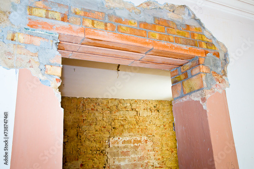 New reinforced brick lintel useful for creating a new door, or a new window, in an old stone and brick wall in a construction site photo