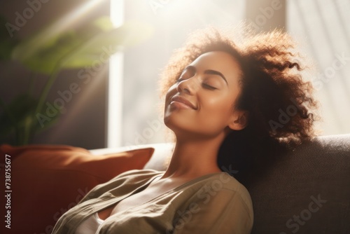 woman relaxing on sofa at home in living room  resting after a hard day work  closed eyes  put hands behind head  smiles happily. Relaxation  self care  enjoy life concept