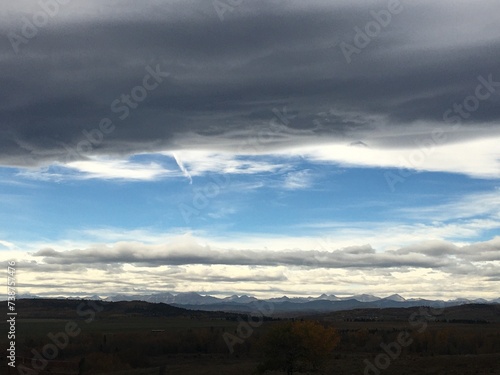 The rolling prairie of Longview Alberta topped with the grey solitude of a Chinook cloud formation. 