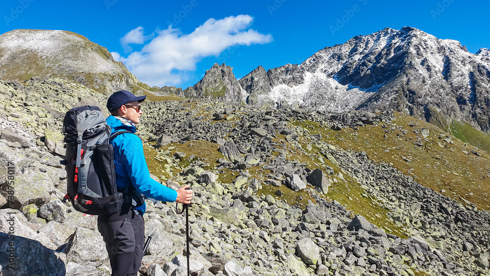 Hiker man on alpine meadow with panoramic view of majestic mount Schoenbretterkogel, High Tauern National Park, Carinthia, Austria. Idyllic hiking trail in Austrian Alps. Wanderlust paradise Mallnitz