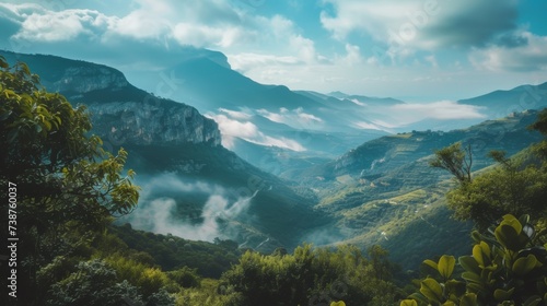 A foggy mountain range towers over a lush green valley, with trees and clouds adding to the breathtaking landscape of this serene highland wilderness