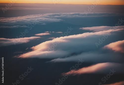 The view from the airplane window to the clouds and sunset. Airplane wing above thick pink and orange clouds. Wonderful breathtaking view. © Алексей Ковалев