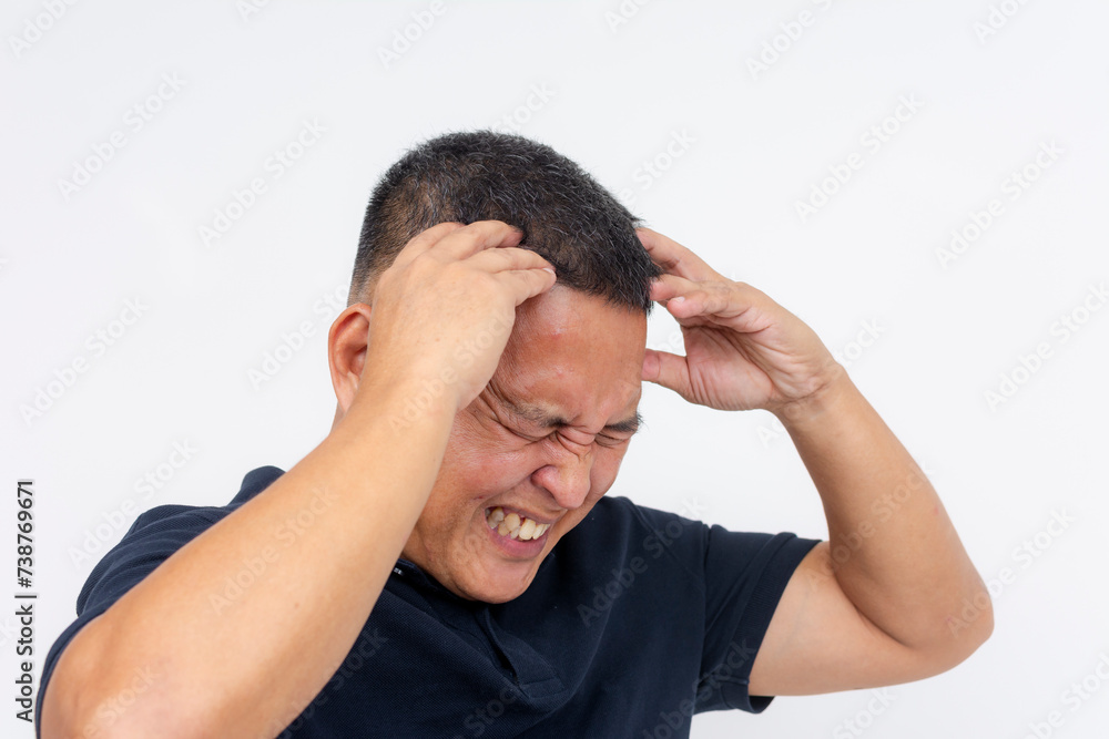 A middle-aged asian man with pained expression holding his head, indicating an excruciating migraine or headache. Isolated on white. A middle-aged asian man with pained expression holding his head, indicating an excruciating migraine or headache. Isolated on white.