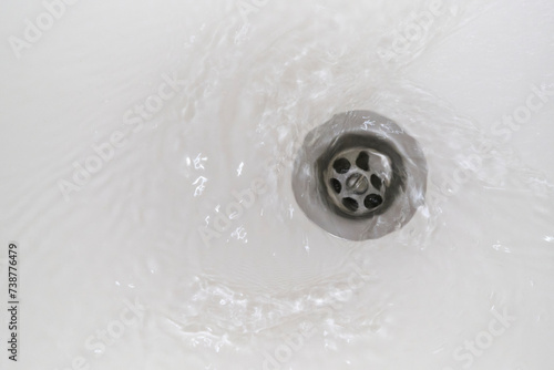 Swirl of water flows down the drain in the bathroom.