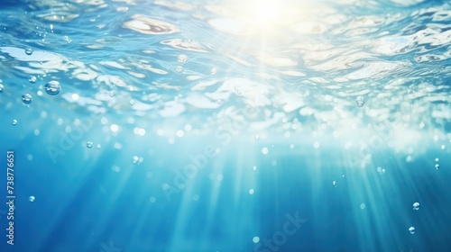 Blurry blue water surface with bubbles and splashes Nature background with sunlight