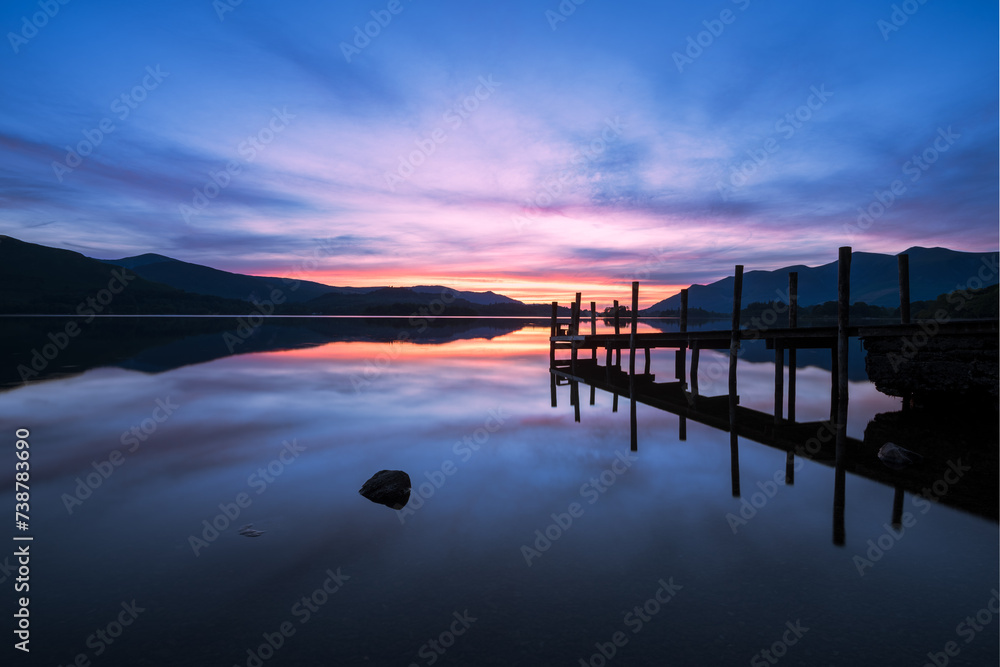 Vivid sunset colours with reflections in Derwentwater at Ashness Jetty, Lake District, UK.