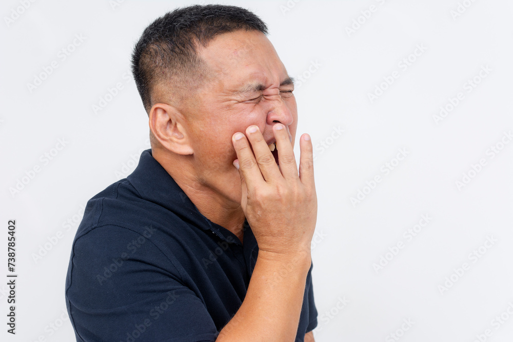 A middle aged Asian man with experiencing excruciating pain, holding his cheek due to a toothache. Potential exposed nerve in the tooth. A middle aged Asian man with experiencing excruciating pain, holding his cheek due to a toothache. Potential exposed nerve in the tooth.