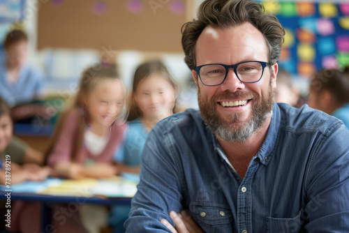 Portrait of smiling male teacher in a class at elementary school looking at camera photo