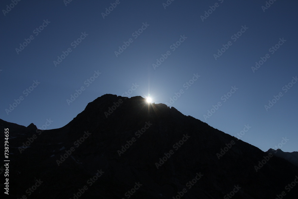 The sun's radiant rays illuminate the mountain peak, casting a bright and beautiful glow upon the landscape.