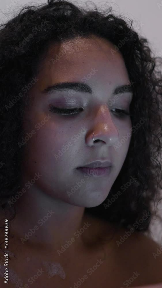 Close up of a curly haired woman texting on her phone Close up of a curly haired woman texting on her phone