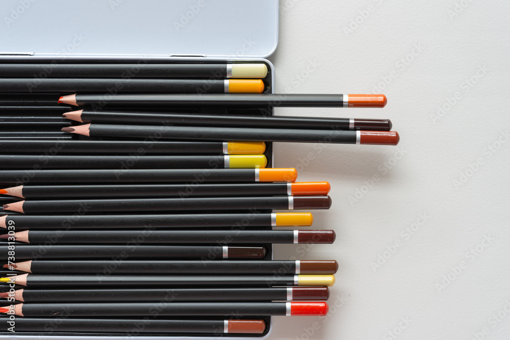 Fototapeta premium dusty color pencils in metal box on paper