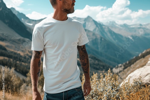 Ein Mann in einem weißen T-shirt vor einer schönen Berglandschaft, T-shirt Mockup  photo