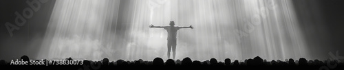 The silhouette of the winner's figure with outstretched arms in the spotlight in front of the audience photo
