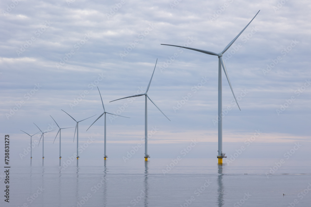 Off shore wind turbines or wind mills at a flat, calm sea, no wind