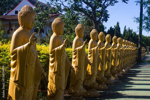 Yellow statues making hand gestures at the Chen Tien Buddhist temple in Foz do Iguaçu, Brazil photo