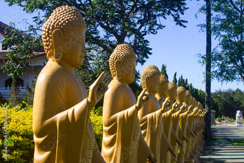 Yellow statues making hand gestures at the Chen Tien Buddhist temple in Foz do Iguaçu, Brazil