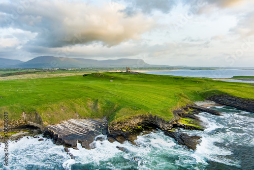Classiebawn Castle on a backdrop of picturesque landscape of Mullaghmore Head. Spectacular sunset view with waves rolling ashore. Signature point of Wild Atlantic Way, Co. Sligo, Ireland