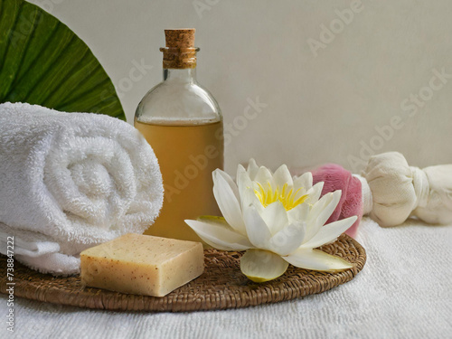 Gua sha facial stone, cosmetic bottles, towels and candle on wooden background still life stock photo images. Spa and wellness setting with massage stone. Beauty spa treatment composition images