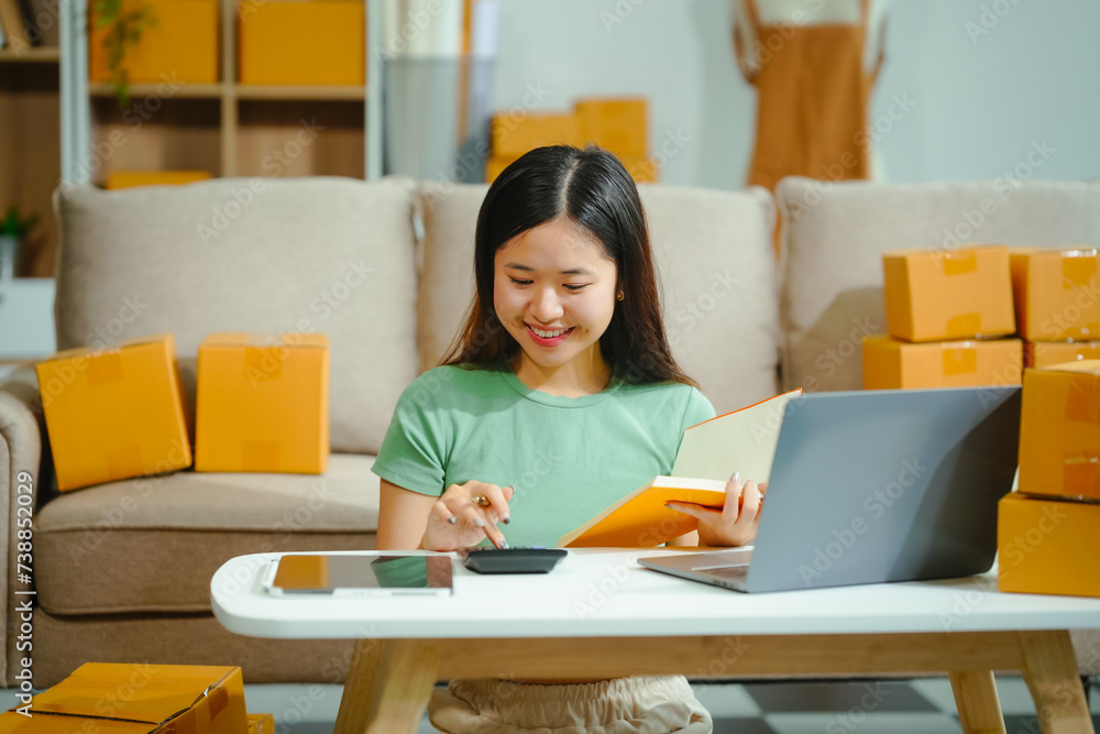 young Asian entrepreneur, the owner of a small clothing store, organizes online live streams showcasing products packaged in cardboard boxes, ensuring prompt and efficient delivery. young Asian entrepreneur, the owner of a small clothing store, organizes online live streams showcasing products packaged in cardboard boxes, ensuring prompt and efficient delivery.
