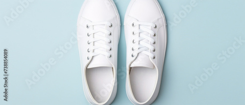 Two pristine white sneakers sitting on a simple backdrop  portraying cleanliness and simplicity.