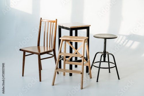 a group of chairs and stools are sitting next to each other on a white surface