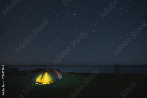 Wild camping with a tent on the shore of the steep Baltic Sea in Paldiski under the starry sky.