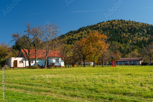 farma u podnóża góry w kolorowym jesiennym krajobrazie © piotr