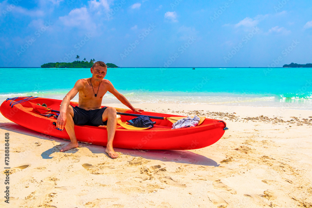 Tourist man kayaking canoe boat water on Rasdhoo island Maldives. Tourist man kayaking canoe boat water on Rasdhoo island Maldives.