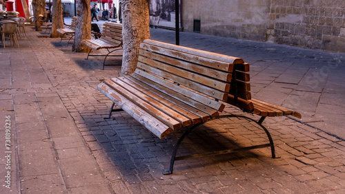 Photography lonely bench on a busy street of the old town