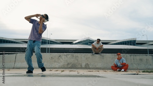 Group of skilled break dancer perform street dance with friend looking and cheering at him. Handsome hipster practice b boy dance at street while listening to music. Outdoor sport 2024. Sprightly.