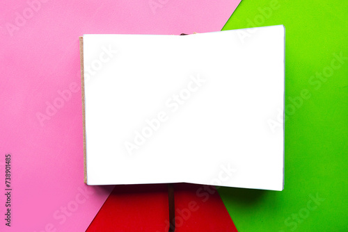 Open notebook on geometric green, blue and pink background photo