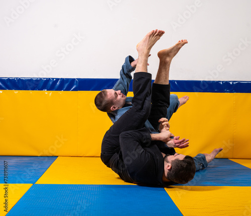 Young girls and boys practice Brazilian jiu jitsu in the gym