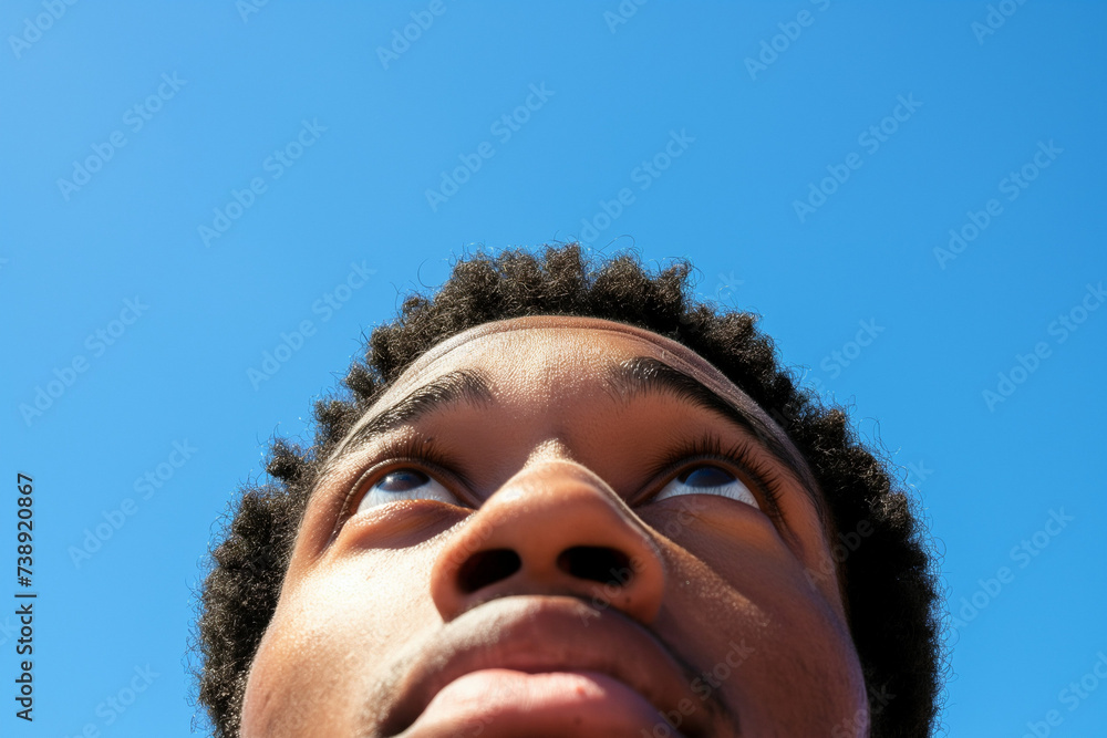 Close-up of a man looking up with hope in his eyes, clear blue sky in the background, embodying optimism and aspirations Close-up of a man looking up with hope in his eyes, clear blue sky in the background, embodying optimism and aspirations