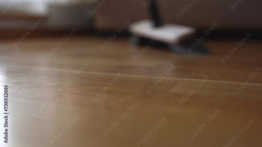 A focused image showing a cleaning brush and scattered dust on a wooden surface, highlighting household chores
