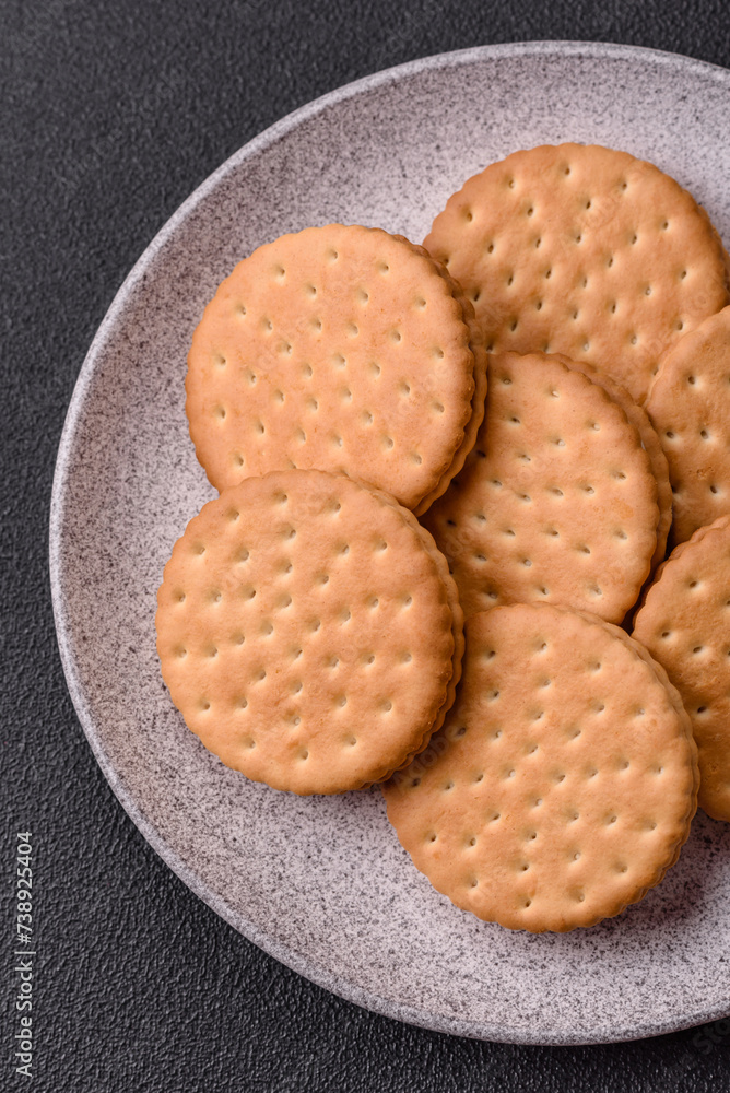 Round dotted snack snack cookies with cream on a dark concrete background Round dotted snack snack cookies with cream on a dark concrete background