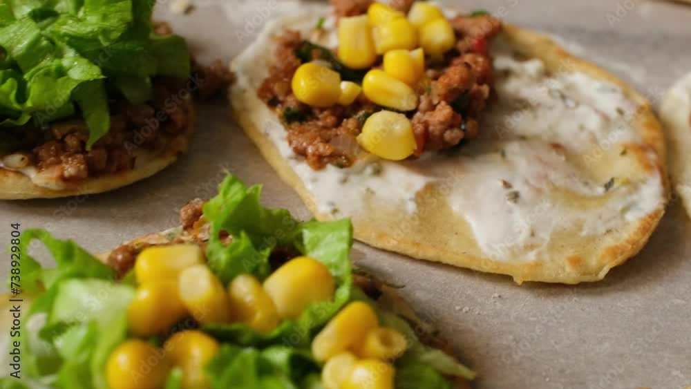 Rolling out taco dough and filling it with foods such as chicken, meat and fish on the gray table Rolling out taco dough and filling it with foods such as chicken, meat and fish on the gray table